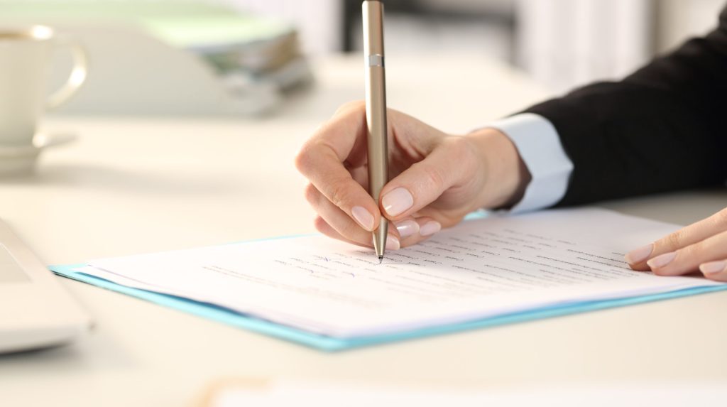Business woman hands filling out form in the office